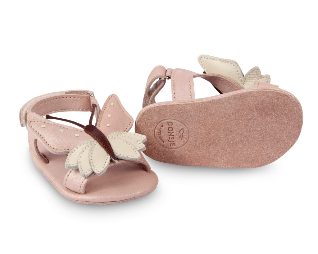 US stockist of Donsje USA's Butterfly Tuti Sky  premium handmade leather sandals.  Pink in color with beautiful cream/pink butterfly on front and velcro fastening at back.  Sizes 0-12 mths have soft sole, 12-30mths have a soft flexible, rubber sole.