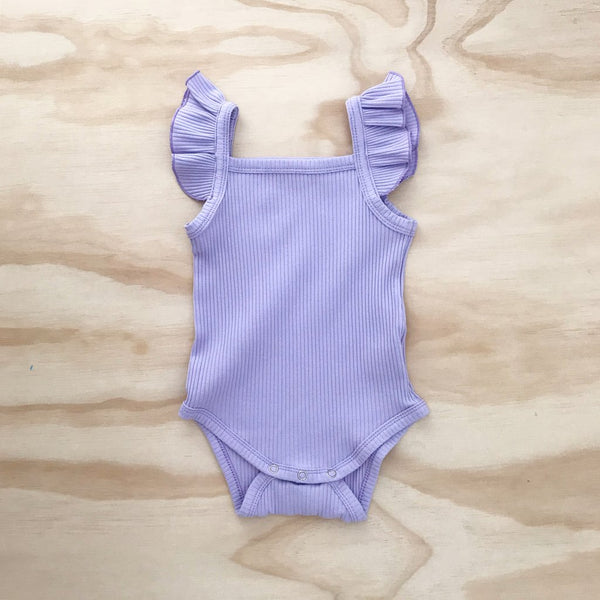 US stockist of Bel & Bow's ribbed cotton lilac bodysuit with flutter details on shoulder straps and snaps at crotch.