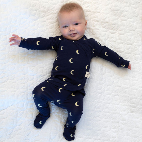 Stockist of Bonsie Babywear's Footed, dark blue "Gnight Moon" kimono style romper featuring a crescent moon print