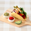 US stockist of Tara Treasures. Felt taco set with toppings on a wooden board against a checkered background