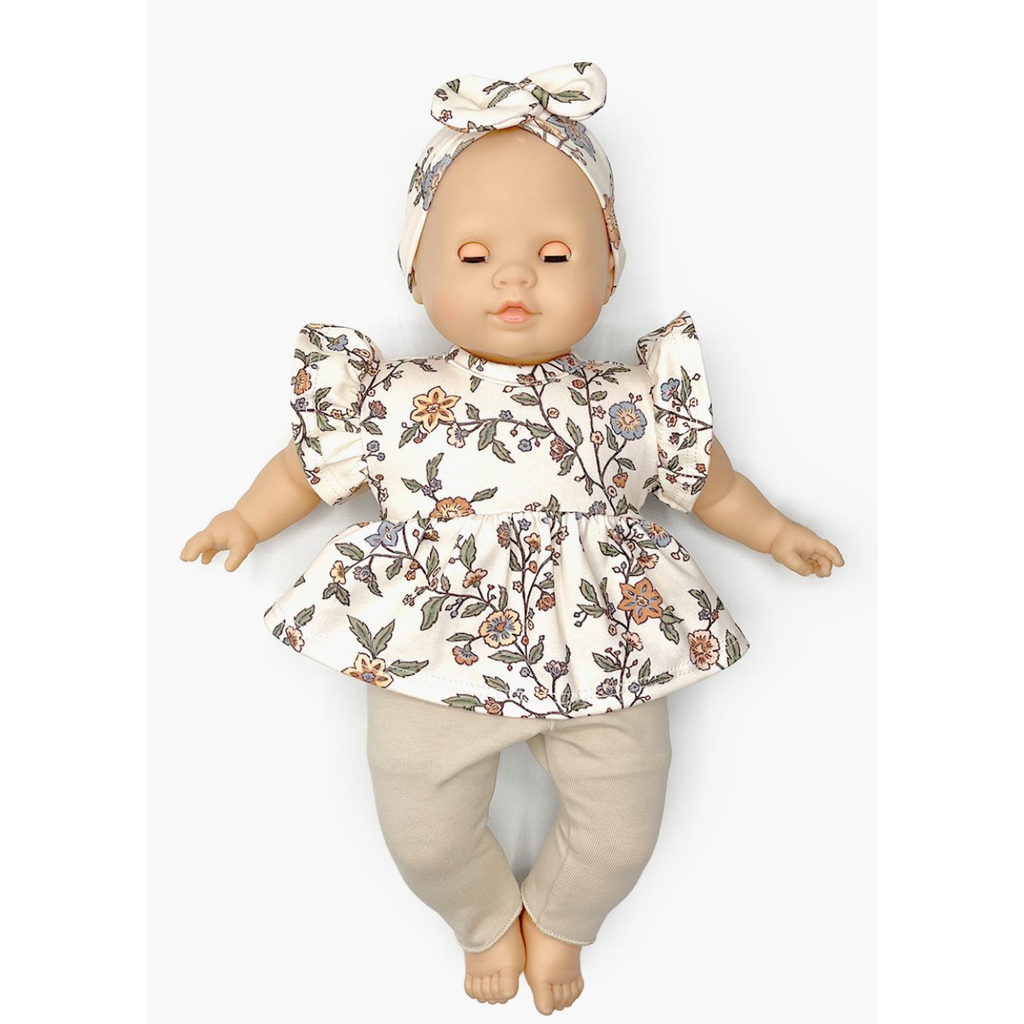 US stockist of Minikane's Emilie Sleepy doll dressed in a Carlota top with matching headband and beige leggings.