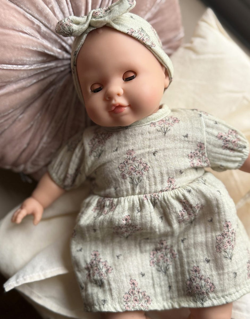US stockist of Minikane's Emilie Sleepy doll dressed in a Faustine dress with matching headband 