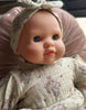 US stockist of Minikane's Emilie Sleepy doll dressed in a Faustine dress with matching headband 
