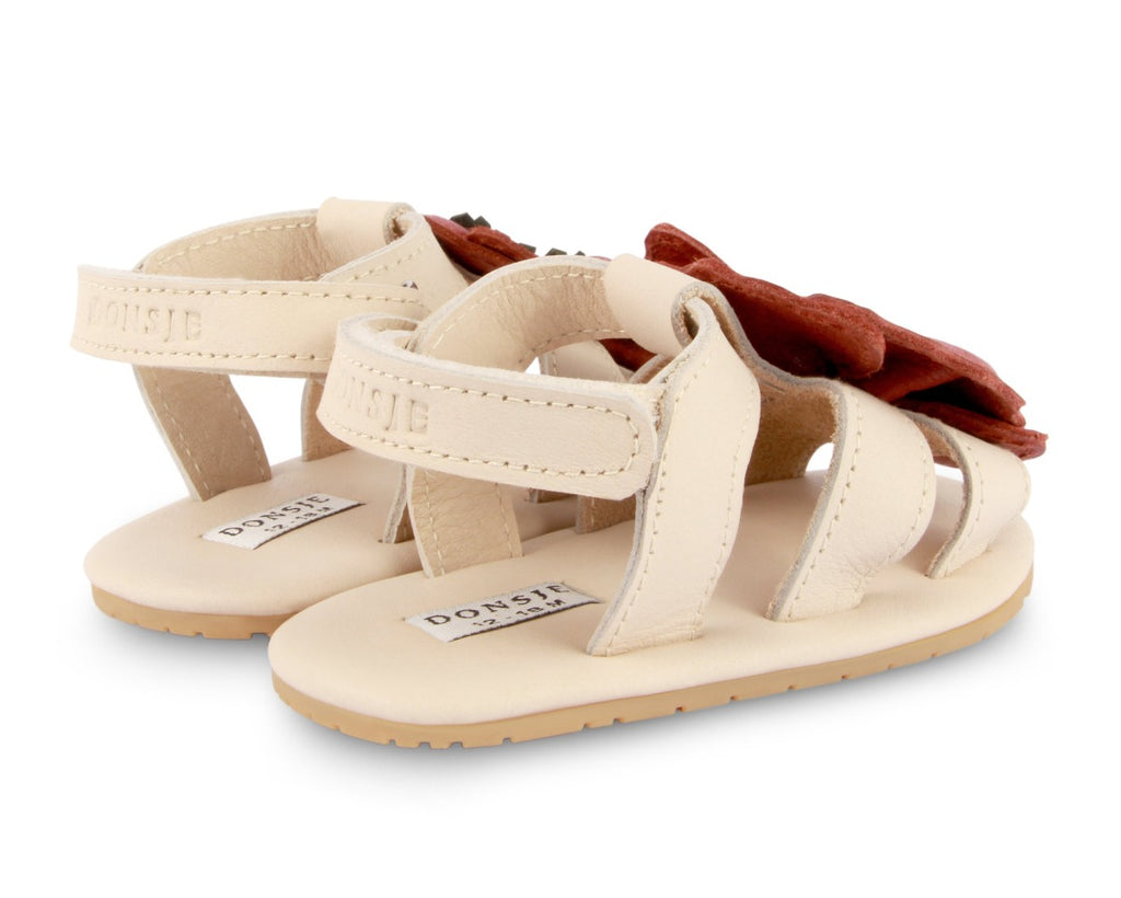 US stockist of Donsje USA's Poppy Tuti Fields premium handmade leather sandals.  Cream in color with beautiful red poppy on front and velcro fastening at back.  Sizes 0-12 mths have soft sole, 12-30mths have a soft flexible, rubber sole.