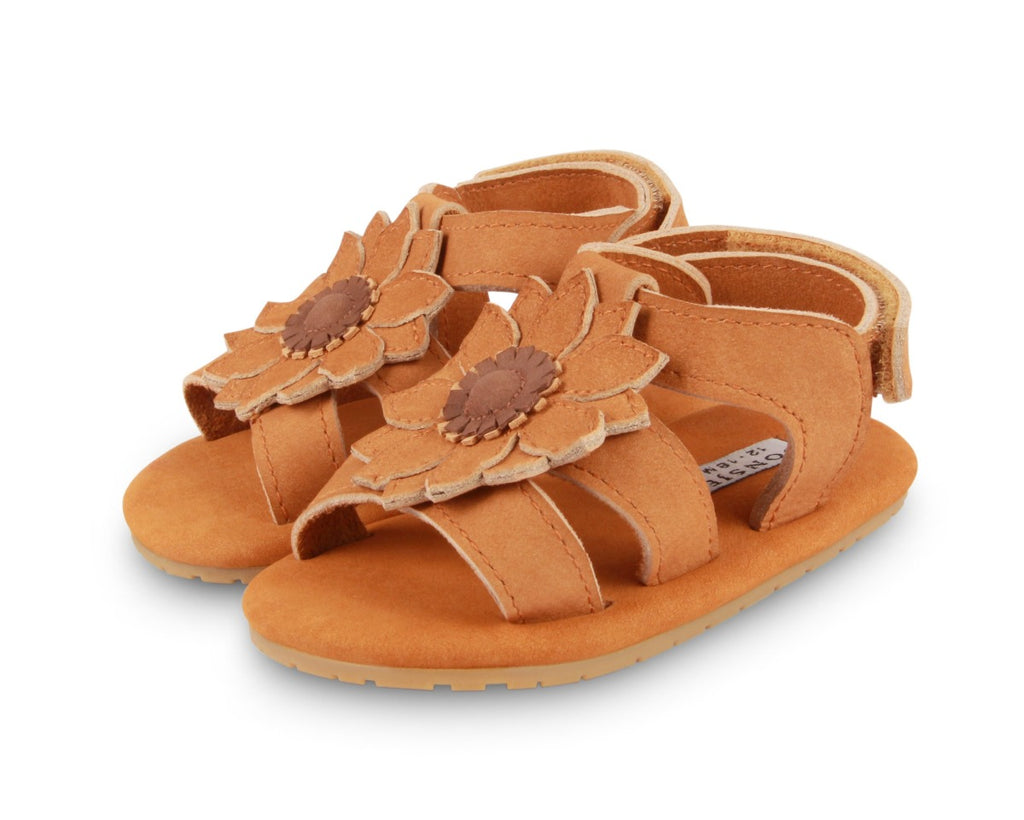 US stockist of Donsje USA's Poppy Tuti Fields premium handmade leather sandals.  Tan in color with a lovely tan sunflower on front and velcro fastening at back.  Sizes 0-12 mths have soft sole, 12-30mths have a soft flexible, rubber sole.