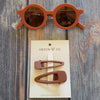 US stockist of Grech & Co's gender neutral sustainable sunglasses.  Made from recycled plastic, with round amber lens with UV 400 protection in a rust color.
