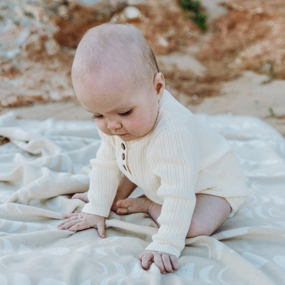 US stockist of Grown Clothing's gender neutral, organic cotton ribbed button bodysuit in Milk.