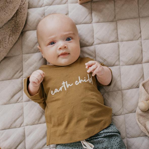 US stockist of Buck & Baa's organic cotton "Earth Child" short sleeve t-shirt.  Boxy fit, with white "Earth Child" printed across the chest.  Ochre color.