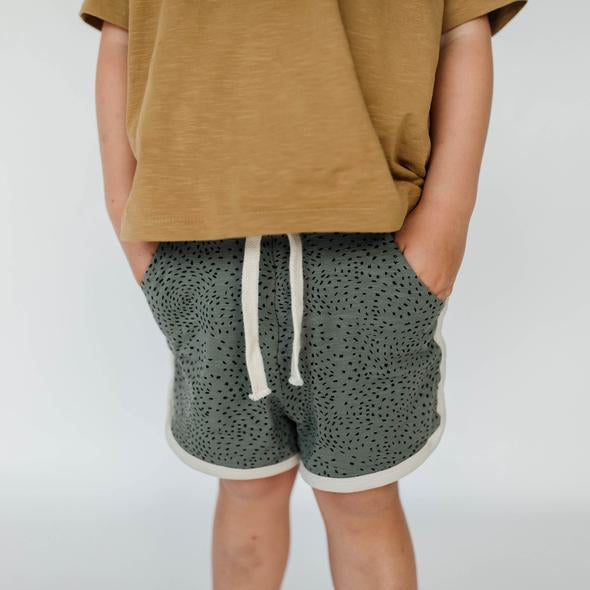US stockist of Buck & Baa's organic cotton, gender neutral blue/green dapple shorts.  Features elastic waist with drawstring and side pockets. 