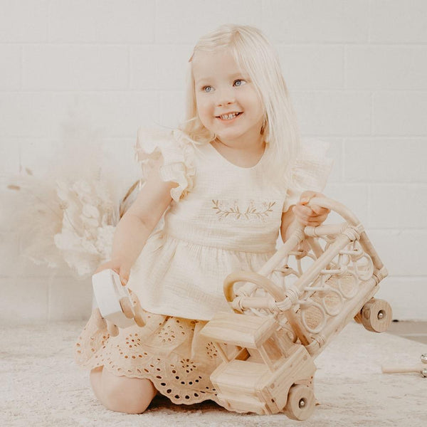 US stockist of India and Grace's Embroidered Ruffle Peplum Top in cream.  Made from cotton with shell buttons at the back, ruffle sleeves and floral embroidery on the chest. 