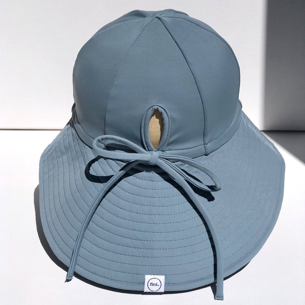 US stockist of Fini the Label's gender neutral, floppy swim hat in heaven. Features elongated back for added sun protection, chin strap and adjustable bow around crown for better fit. Brim is medium stiffness and can be flipped up at front.  Made from nylon/spandex and is quick drying.