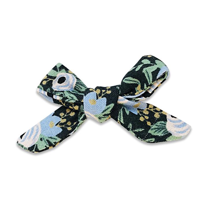 US stockist of Josie Joan's Jemima petite bow hair clip.  Dark colored fabric with blue and white flowers with contrasting green foilage and yellow berries.