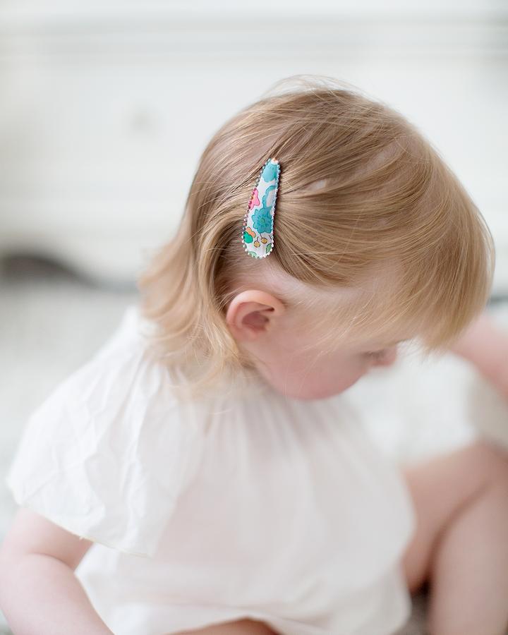 US stockist of Josie Joan's Kylie set of two fabric hair clips.  Cream colored fabric with blue, green flowers and red, yellow berries. Features scalloped edges.