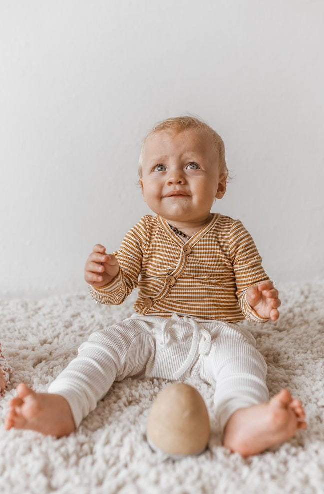 US stockist of Two Darlings gender neutral Mustard Stripe stretch rib cotton bodysuit. Long Sleeves with 4 non functional wooden buttons kimono style across the front.