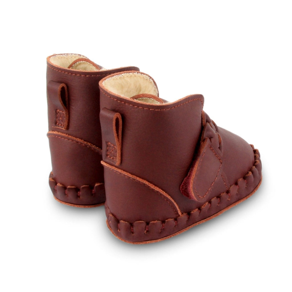 US stockist of Donsje's Burgundy classic leather  baby shoes with Mace faux fur lining.  Velcro braided fastening - soft sole under 12mths.