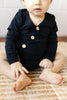 US stockist of Two Darling's long sleeve bamboo/cotton midnight blue bodysuit. Kimono style crossover front with four functioning wooden buttons.  Snaps at crotch.
