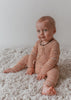 US stockist of Two Darlings gender neutral Mustard Stripe stretch rib cotton bodysuit. Long Sleeves with 4 non functional wooden buttons kimono style across the front.