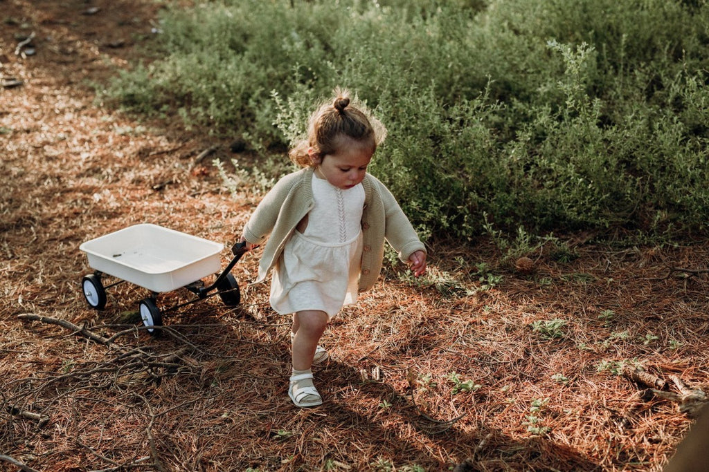 US stockist of Grown Clothing's slub linen dress in oat.  Made from a cotton line blend, with adjustable straps that tie in a bow at the back.  Features a rolled hem and sweet pointelle knit details down the front of the dress.
