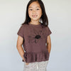 US stockist of Buck & Baa's organic cotton peplum top in plum.  Features short sleeves and black daisy print on front.