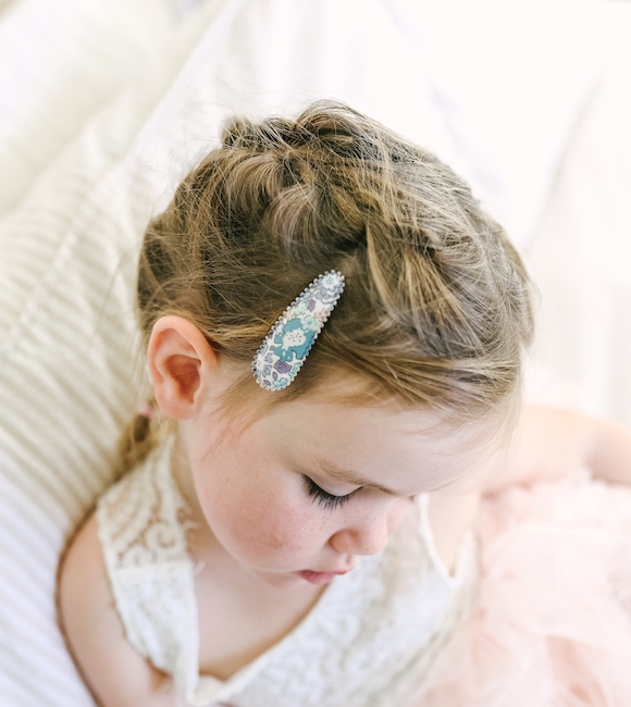 US stockist of Josie Joan's Suzanne set of two fabric hair clips.  Pale colored fabric with pastel flowers in hues of pink, purple, blue and yellow. Features scalloped edges.