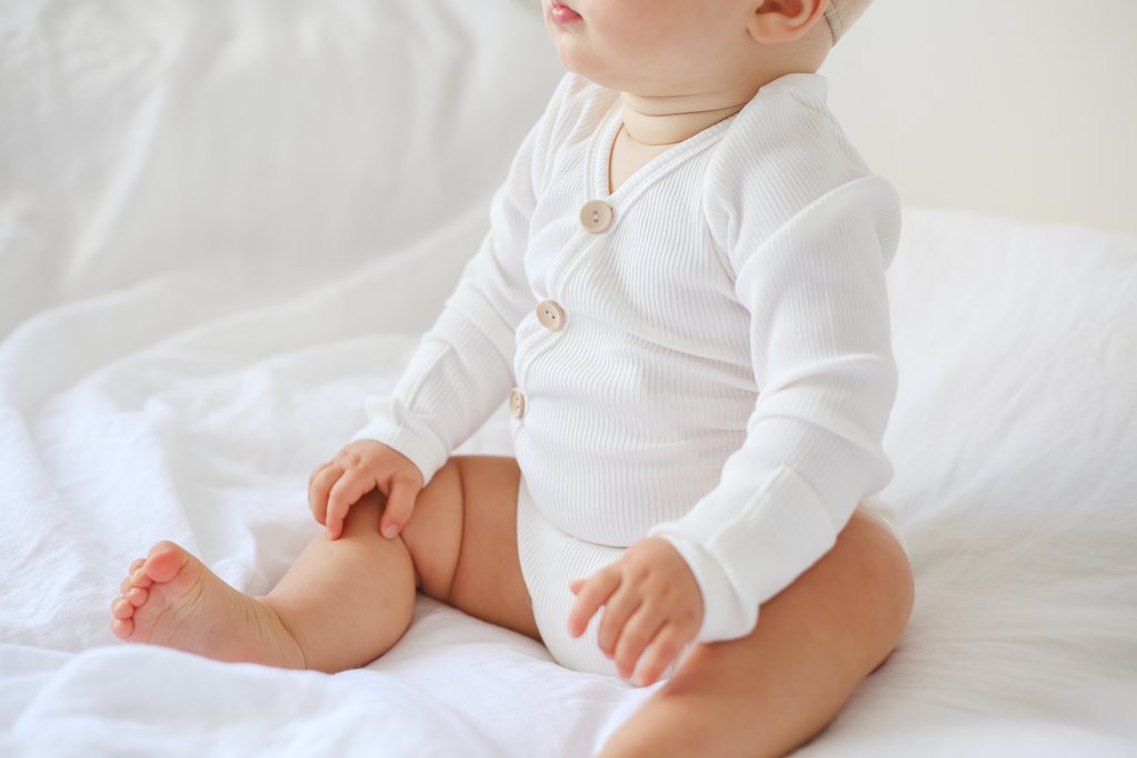 US stockist of Two Darlings gender neutral Milk stretch rib cotton bodysuit. Long Sleeves with 4 non functional wooden buttons kimono style across the front.