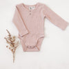 US stockist of Karibou Kids soft pink Willow long sleeve henley bodysuit in ribbed cotton blend.