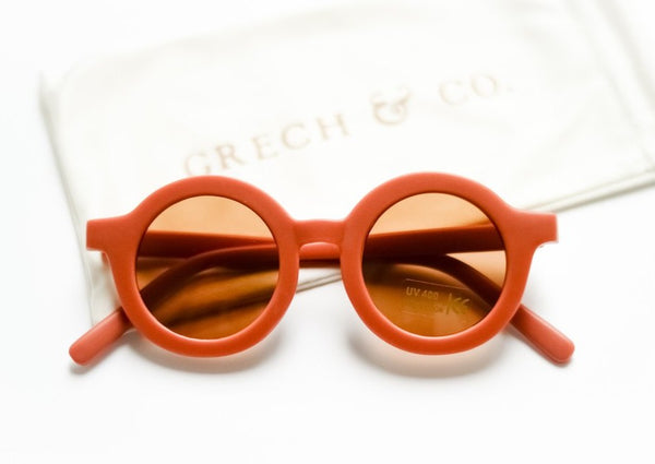 US stockist of Grech & Co's gender neutral sustainable sunglasses.  Made from recycled plastic, with round amber lens with UV 400 protection in a rust color.