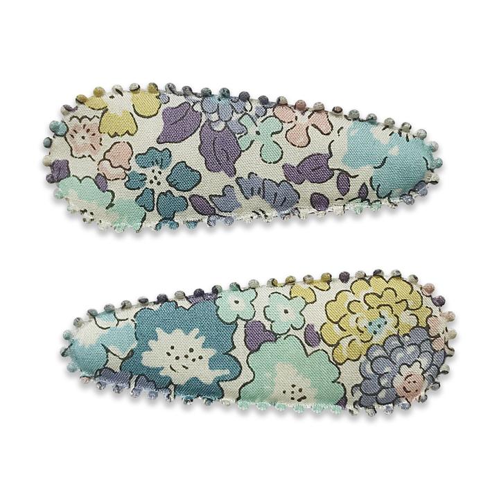 US stockist of Josie Joan's Suzanne set of two fabric hair clips.  Pale colored fabric with pastel flowers in hues of pink, purple, blue and yellow. Features scalloped edges.