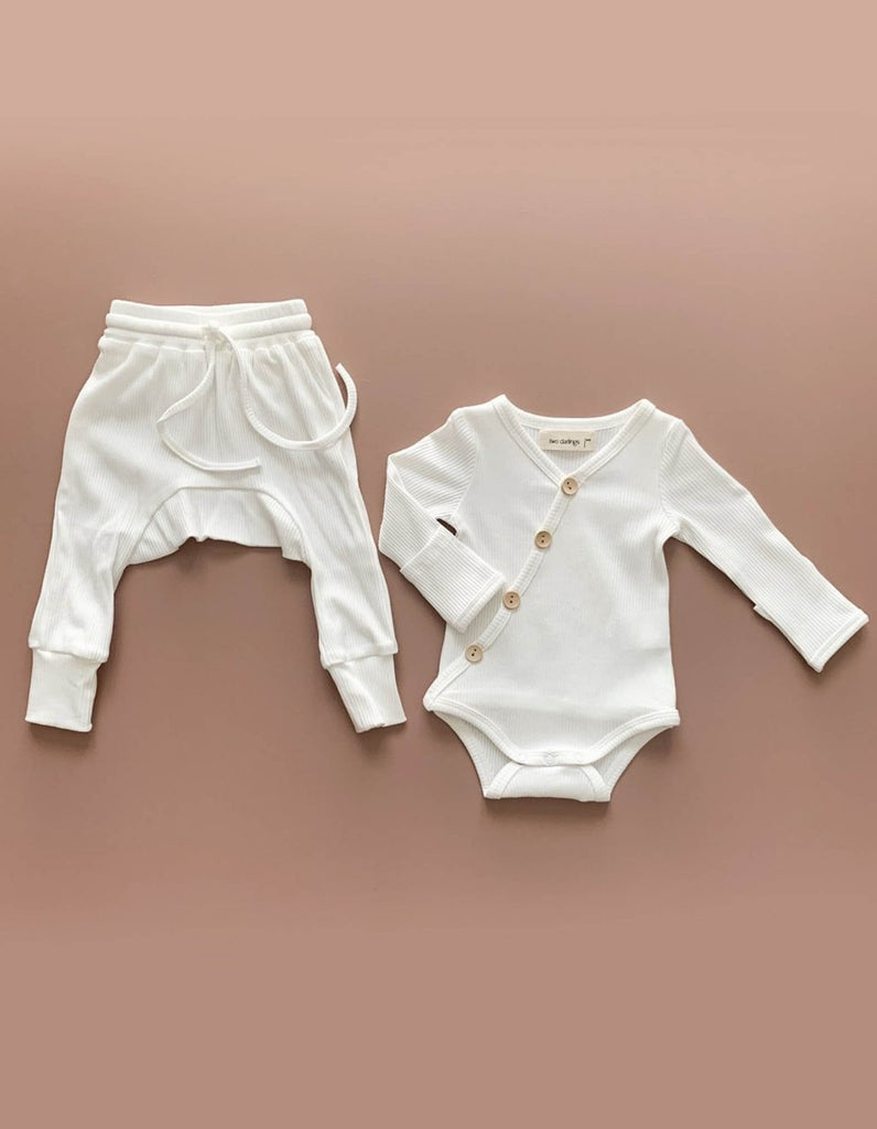 US stockist of Two Darlings gender neutral Milk stretch rib cotton bodysuit. Long Sleeves with 4 non functional wooden buttons kimono style across the front.