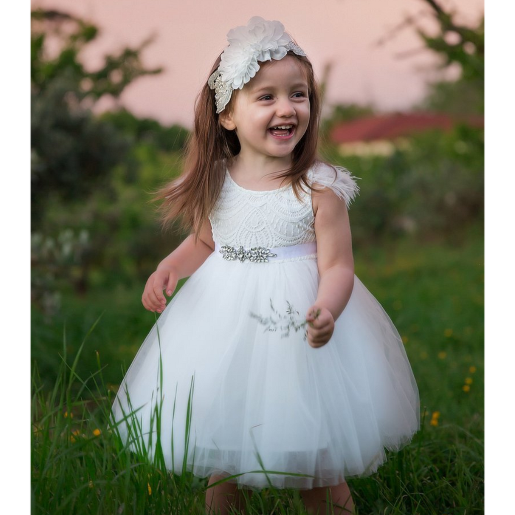 US stockist of Karibou Kids white Angelina Feather and Lace Dress.  Features 5 layer full skirt, lace bodice, scoop back and ostrich feather flutter sleeves. 
