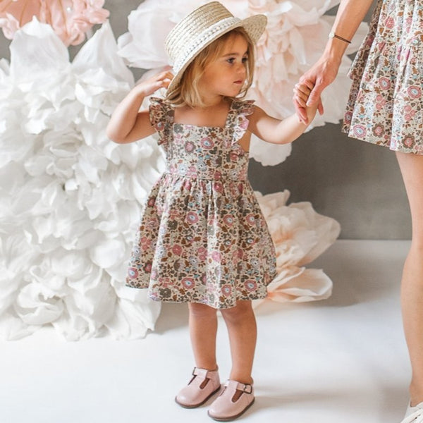 US stockist of Karibou Kids cotton Wild Meadow sunshine dress.  In muted florals, with pretty flutter sleeves, adjustable straps and an open back.