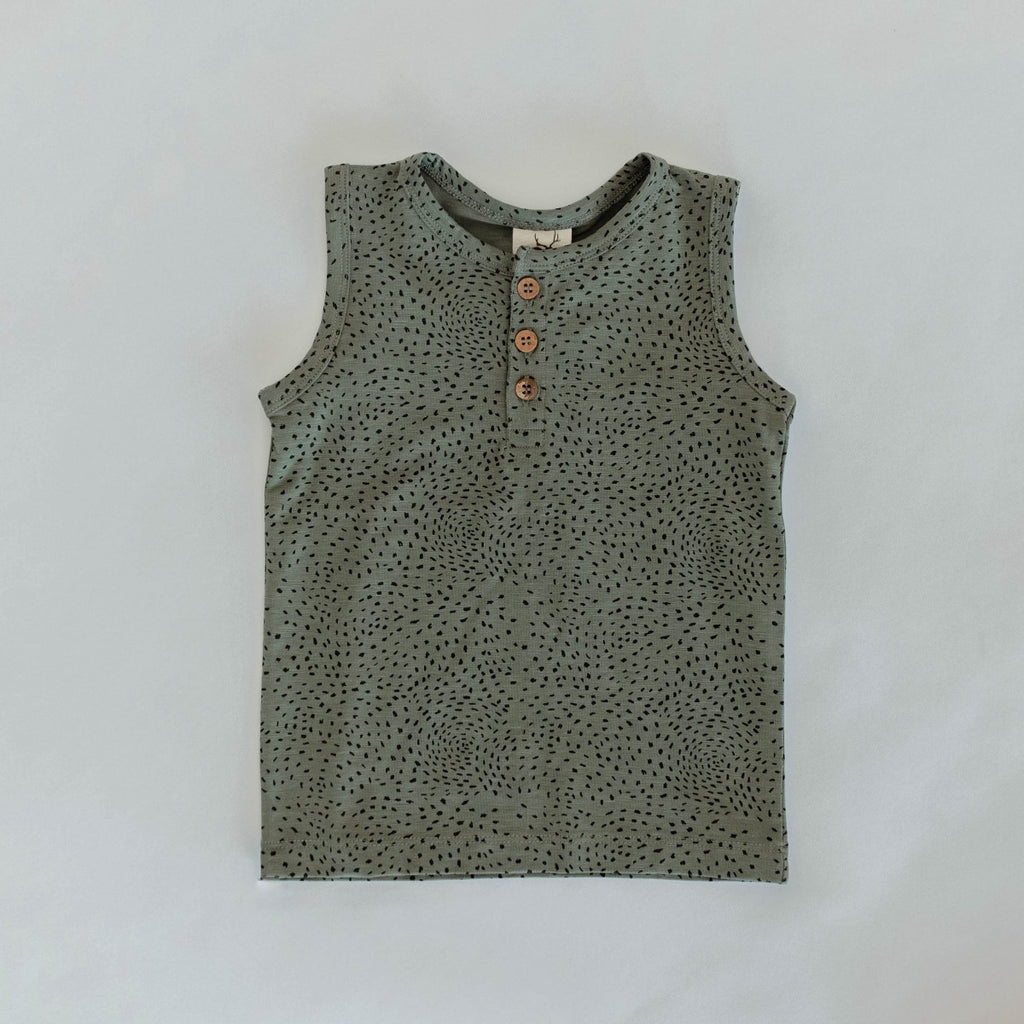 US stockist of Buck & Baa's organic dappled henley tank top.  Made from organic cotton and elastane in a blue/green color with all over spotted print. Coconut buttons on front placket.