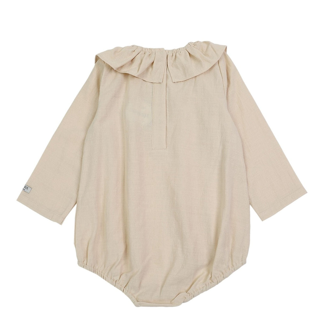 US stockist of Donsje's long sleeve chloe bodysuit in Buttercream.  Made from cotton with a ruffle neck.
