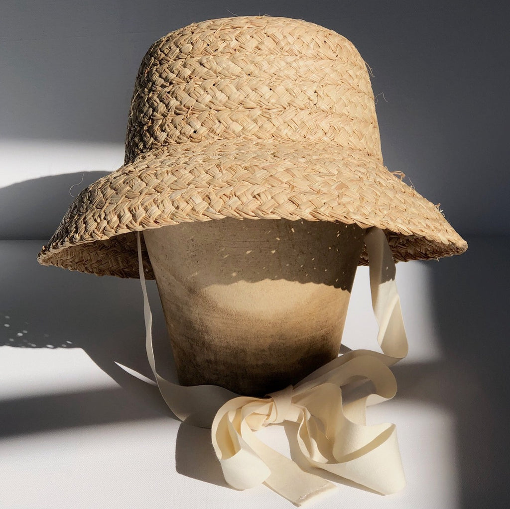 US stockist of Fini the Label's vintage French style straw hat.  Made from raffia straw with a wide bell shaped brim and a trimmed natural ribbon beget chin strap.