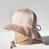 US stockist of Fini the Label's gender neutral, floppy swim hat in Shimmer Champagne. Features elongated back for added sun protection, chin strap and adjustable bow around crown for better fit. Brim is medium stiffness and can be flipped up at front.  Made from nylon/spandex and is quick drying.