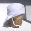 US stockist of Fini the Label's gender neutral, sailor swim hat in white. Features elongated back for added sun protection, wide brim and chin strap. Brim is medium stiffness and can be flipped up at front. Sides can be worn buttoned up for that sailor look.  Made from nylon/spandex and is quick drying.