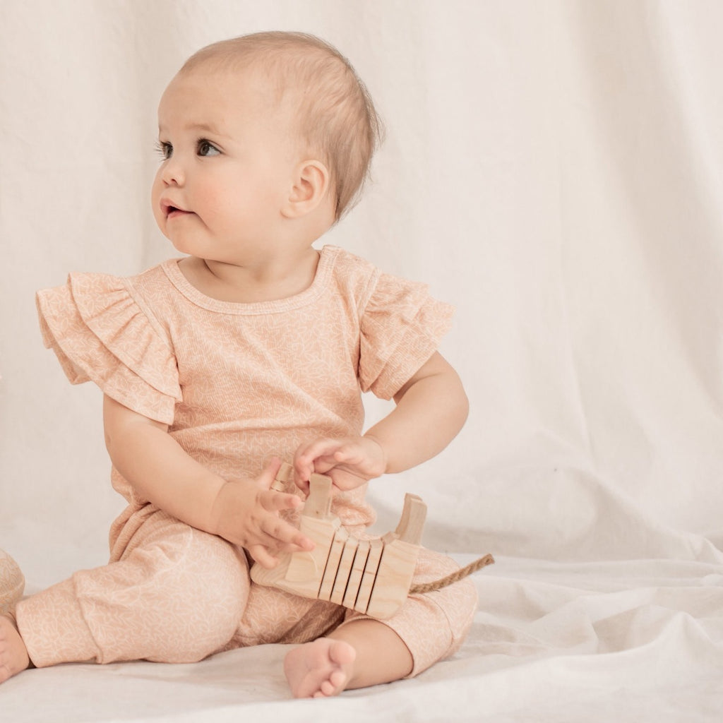 US stockist of India & Grace's short sleeve Dusty Pink Floral Ruffle Romper, made from soft ribbed cotton.  Features double ruffle sleeves and snaps at crotch.